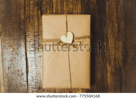 Handcraft gift boxe with red heart on a wooden table. Top View