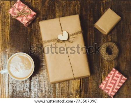 Coffee cup and  handcraft gift boxes with red heart on a wooden table. Top view