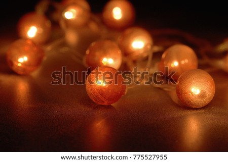Electric garland with red lanterns covered with frost on a black background.