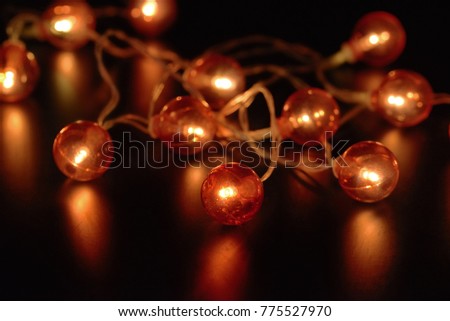 Electric garland with red light bulbs on a black background.
