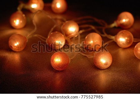 Electric garland with red light bulbs covered with frost on a black background.