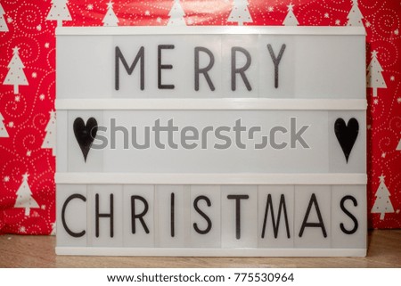 lightbox with text merry christmas and red wbackground with fir trees images