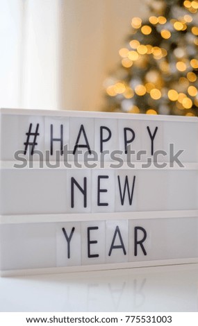 lightbox with tag text happy new year and led lights blurred bokeh background, christmas decoration