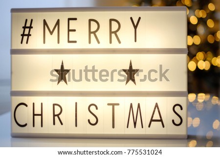 lightbox with text merry christmas and led lights blurred bokeh background, christmas decoration