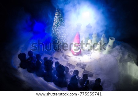 Chess in the snow. winter concept. Christmas or New Year present on a chessboard with Santa Claus on a dark background. Copy space. Selective focus