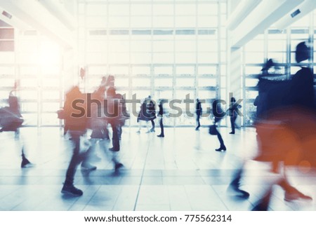 crowd of anonymous people walking in a modern environment