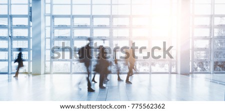 Anonymous blurred business people walking in a modern environment