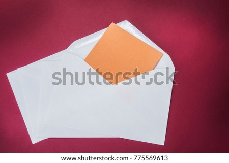 One opened white envelope on the red background