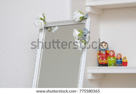 london, england, 05/05/2017, A beautiful white rustic vintage mirror with white roses in a white airy bright clear room. The mirror has a fantasy feel. 