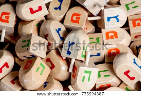 Group of wooden dreidels - traditional game for the Jewish holiday of Hanukkah. Colorful Hebrew letters, decorative design, bright  tones.  Israel flea-market.