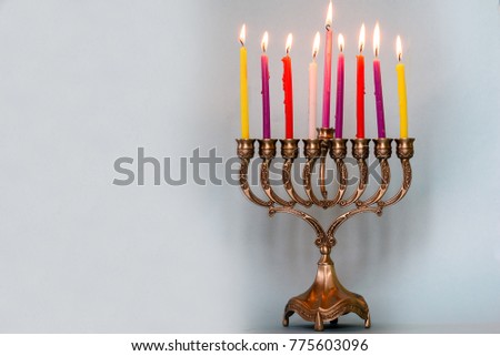 Eighth day of Hanukkah with burning Hanukkah colorful candles in Menorah (traditional Candelabra) .Chanukkah-jewish holiday. Each night, another candle is added. Copy space for text.