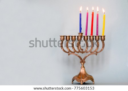 Fourth day of Hanukkah with burning Hanukkah colorful candles in Menorah (traditional Candelabra) .Chanukkah-jewish holiday. Each night, another candle is added. Copy space for text.