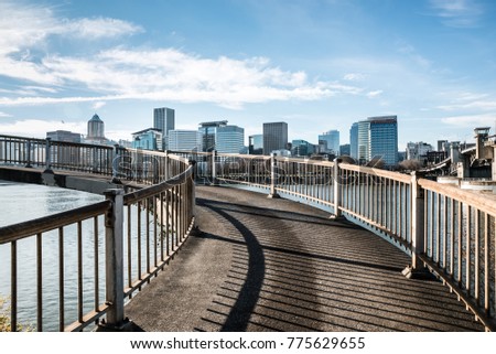 Spiral pedestrian bridge overlooking the Willamette River and the downtown city skyline in Portland, Oregon December 2017 