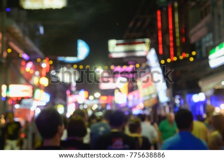 picture in motion blur of people crossing a city walking through the Walking Street in Pattaya,Thailand. Its a tourist attraction primarily for night life