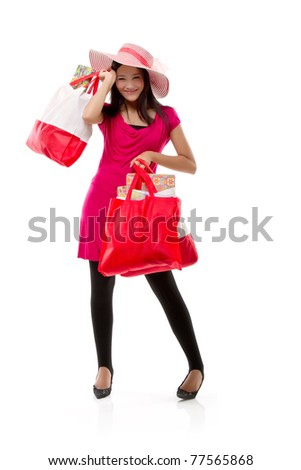 Lovely attractive and pretty young Asian woman wearing hat with shopping bags over white, isolated background