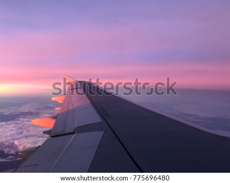aerial sunrise over airplane wing in flight