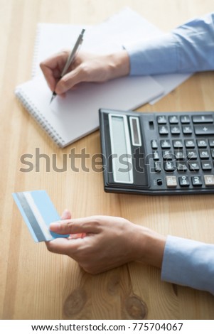 Closeup of Person with Calculator and Credit Card