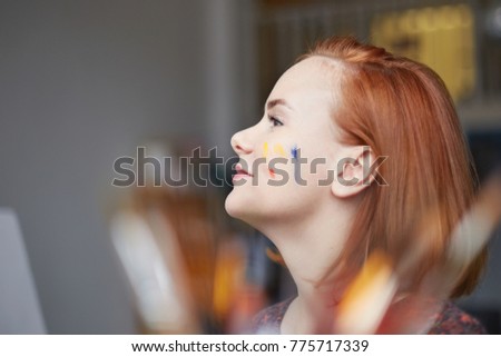Lovely ginger female studying art in workshop, smiling gently in front of her, standing looking at teacher with lovely smile. Woman with red hair found inspiration, going to create something original.