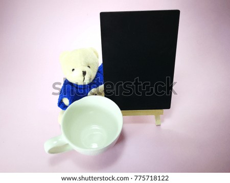 cute bear in a white cup with copy space isolated with pinkish background.