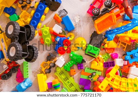 Children's plastic toys on the wooden floor. Natural light, top view. Royalty-Free Stock Photo #775721170