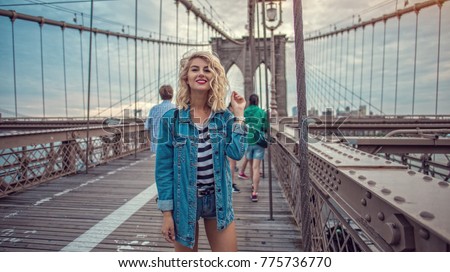 Beautiful hipster girl walking on Brooklyn bridge in New York City 