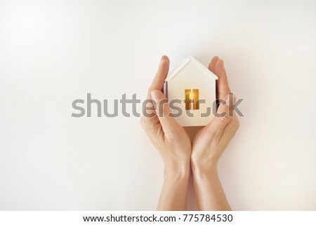 The model of the White House with warm light inside in female hands on a white background Royalty-Free Stock Photo #775784530