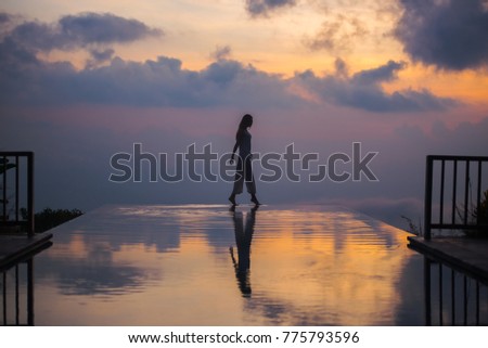 silhouette of a girl in the sunset by the pool