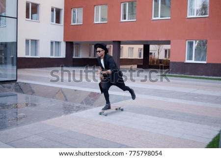 Concept of young,fast and mobile manager. Funny buisinessman on skateboard in black suit. 