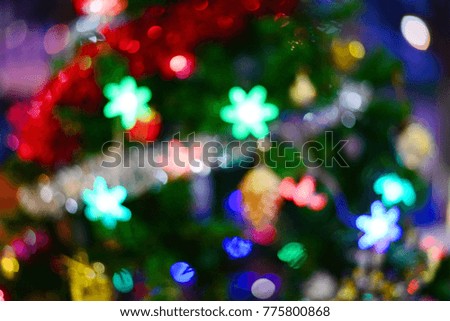 Abstract blurred bokeh lights hanging on tree in the garden at night time.