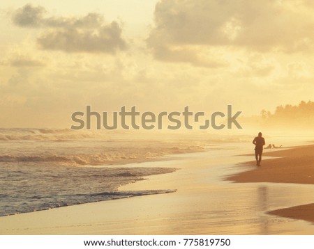 Silhouette of runner on the beach at sunset. Jogging on the beach
