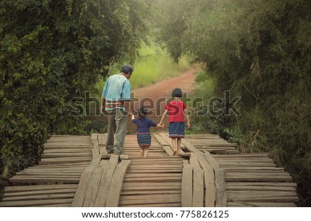 We will not leave you walk alone. Picture of Grandpa and grand child holding hand to walk across the worn bridge.