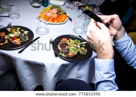 A person takes pictures at a restaurant