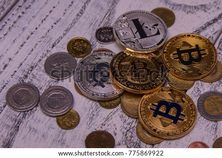silver and gold bitcoins and Silver Litecoin on wooden background