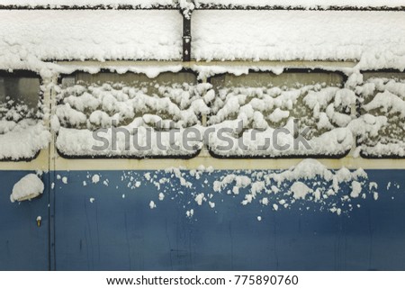 Snow on old blue car. Winter background