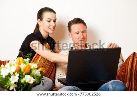 Couple Sitting On The Couch With A Laptop