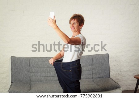 Senior Woman Taking Selfie, Showing Her Weight Loss