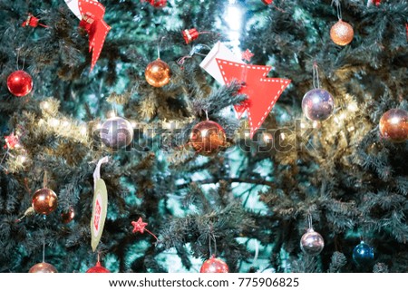 Closeup of a red bauble hanging on a decorative Christmas tree.