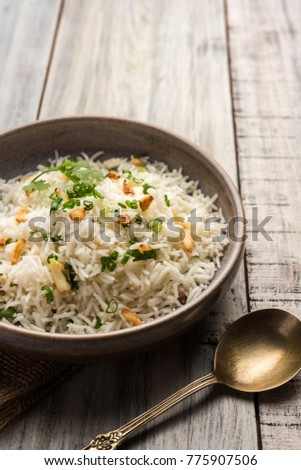 Garlic Fried Rice Or Pulav using Basmati Rice and Lahsun, served with Dal Tadka over moody background, selective focus