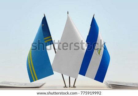 Flags of Aruba and Nicaragua with a white flag in the middle