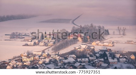 Church and village under the snowy mountains