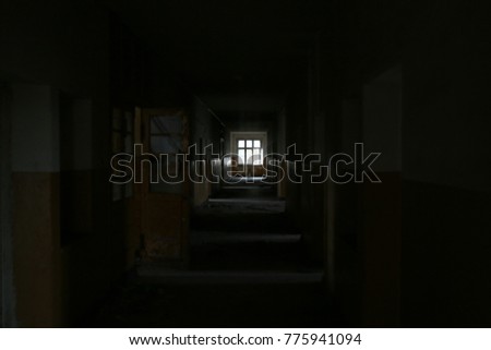 Window in the old hallway of an abandoned hospital .