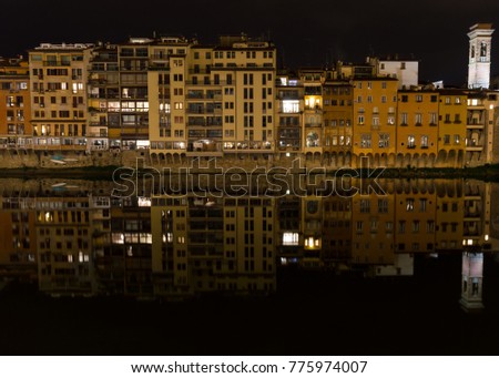 A view of buildings at night along the River Arno in Florence, Italy.