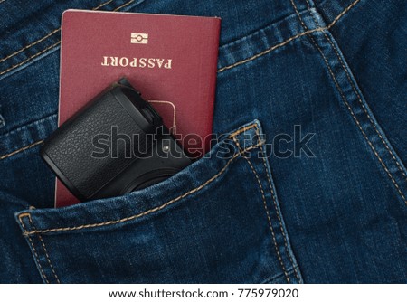 Photo camera and passport in jeans pocket&