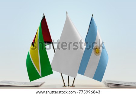 Flags of Guyana and Argentina with a white flag in the middle