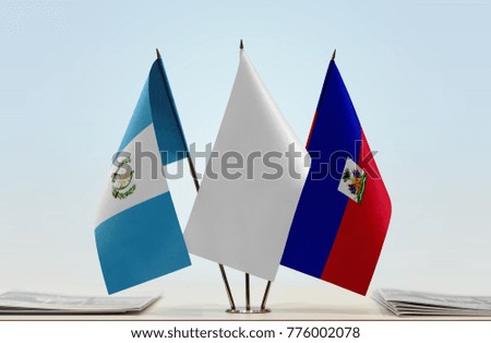 Flags of Guatemala and Haiti with a white flag in the middle