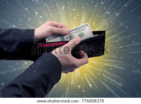 Businessman hand takes out dollar from wallet with fireworks background