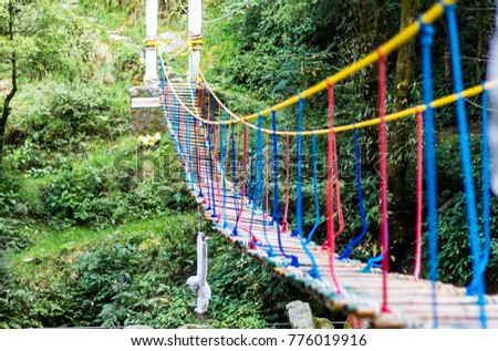 A hanging rope bridge over the waterfall in Panchpula Dalhousie, Himachal Pradesh India. It's for adventure activities for kids and teenagers. Nature's photography in India. Photo filled with colours. Royalty-Free Stock Photo #776019916