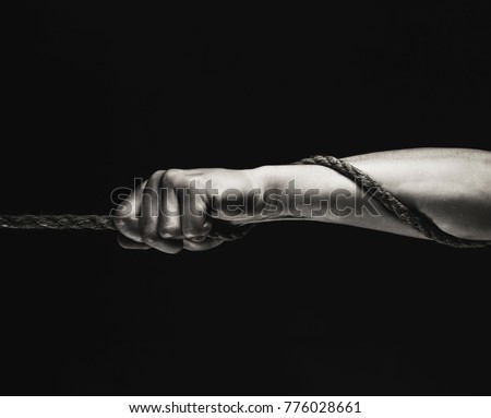 Man's hand holding on to the rope. Hand holding a rope