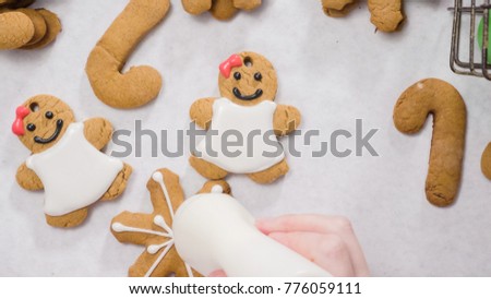 Decorating gingerbread cookies with royal icing for Christmas.