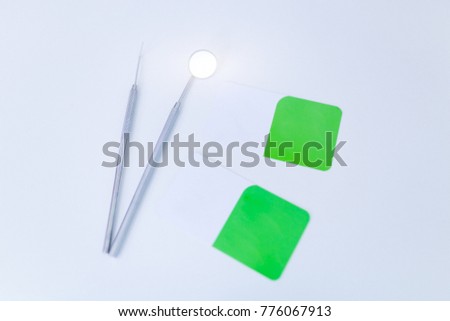 Photo of blank business cards on a white background.In addition, there is dental equipment.